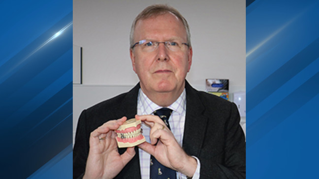 Professor Paul Brunton of The University of Otago in Dunedin, New Zealand poses with the DentalSlim Diet Control device. (Photo: University of Otago)