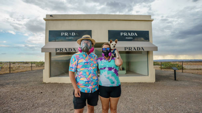 VALENTINE, TEXAS - JULY 14: 'Vanlifers' Josh Brasted (L) and Mary Alice Sandberg pose for a photo in respirators in front of the Prada Marfa sculpture by artists Elmgreen and Dragset during on July 14, 2020 in Valentine, Texas. (Photo by Josh Brasted/Getty Images)