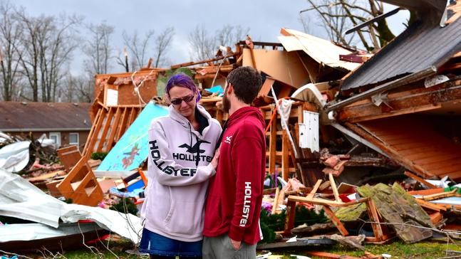 Deanna and Tony Speck, of Cookeville, Tenn., console one another on the front lawn of what's left of Deanna's parent's house off Locust Grove Road on the western edge of Cookeville, Tenn., Tuesday, March 3, 2020. Her parents survived after huddling beneath the staircase as the tornado ripped through the area around 1:30 a.m. (Jack McNeely, Herald-Citizen/The Herald-Citizen via AP)
