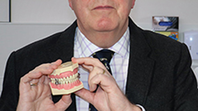 Professor Paul Brunton of The University of Otago in Dunedin, New Zealand poses with the DentalSlim Diet Control device. (Photo: University of Otago)