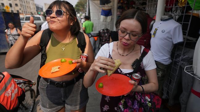 A customer flashes a thumbs up while eating a taco from the Tacos El Califa de León taco stand, in Mexico City, Wednesday, May 15, 2024.  Tacos El Califa de León is the first ever taco stand to receive a Michelin star from the French dining guide. (AP Photo/Fernando Llano)